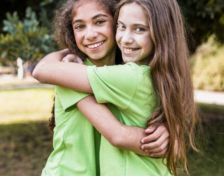 Dos niñas abrazadas sonriendo